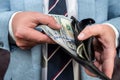 closeup businessman hand holding money dollar in black wallet purse