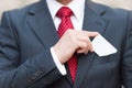 Closeup of Businessman hand holding white business card over suit pocket Isolated on white. Businessman in suit and red tie Royalty Free Stock Photo