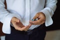 Closeup businessman hands with cufflinks. Man in a business suit, white shirt. Preparing the groom on the wedding day Royalty Free Stock Photo