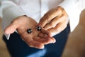 Closeup businessman hands with cufflinks. Man in a business suit, white shirt. Preparing the groom on the wedding day Royalty Free Stock Photo