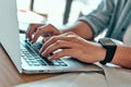 Closeup businessman hands typing on laptop keyboard in cafe