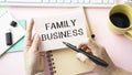 Closeup on businessman holding a card with text FAMILY BUSINESS, business concept image with soft focus