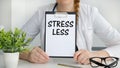 Closeup on businessman holding a card with text LESS STRESS, business concept image with soft focus background Royalty Free Stock Photo