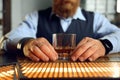 Closeup businessman holding glass of whiskey at bar counter