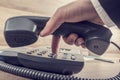 Closeup of businessman making a telephone call by dialing a phon