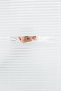 Closeup of a businessman peeking through blinds