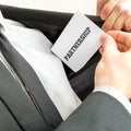 Closeup of businessman placing a business card with word Partner Royalty Free Stock Photo