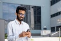 Closeup businessman walking city and using application on smartphone, a smiling Hispanic man holding a phone in his Royalty Free Stock Photo
