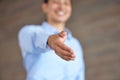 Closeup of a businesswoman giving a handshake. Female employee reaching her hand out to shake on a deal in a modern