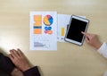 Closeup businesswoman in suit pointing at tablet computer. Document, graph and chart are on wooden table. Top View Royalty Free Stock Photo