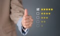 Closeup businesswoman thumb up with checked box on 5 stars rating