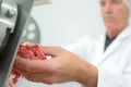 Closeup butcher mincing meat