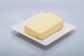 Closeup of butter on a plate under the lights isolated on a grey background