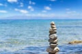 Closeup of Cairn of pebbles, Zen stack of stones on the sea stone beach under blue sky during sunny day in Greece Royalty Free Stock Photo
