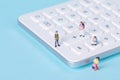 Closeup of a calculator with miniature figurines of students around it choosing a math major Royalty Free Stock Photo