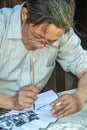 Closeup of Calligraphy Artist at table in street of Tongli, China