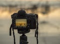 Closeup of a camera on a tripod outdoors. Background Landscape out of focus Royalty Free Stock Photo