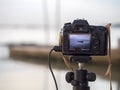 Closeup of a camera on a tripod outdoors. Background Landscape out of focus Royalty Free Stock Photo