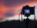 Closeup of a camera on a tripod outdoors. Background Landscape out of focus Royalty Free Stock Photo