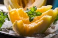 Closeup of cantaloupe melon slices with mint and ice served  on vintage sliver plate Royalty Free Stock Photo