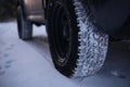 Closeup of car tires in winter on the road covered with snow. All terrain, season tire protector, for all weather conditions. M Royalty Free Stock Photo