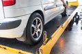 Closeup on car towed onto flatbed tow truck with cable Royalty Free Stock Photo
