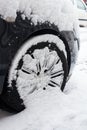 Close up of car wheel covered with snow on street cold winter day