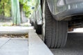 Closeup of a car wheel parked near curb on the side of the street on a parking lot