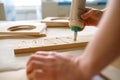 Closeup carpenter applying glue to board wooden timbers