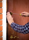 Closeup of carpenter fixing door lock with screwdriver Royalty Free Stock Photo