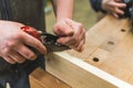 Closeup carpenter planing wood by hand with a planer