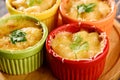 Closeup casserole with baked cheese, chicken and mushrooms in multicolored cocoanuts on wooden boards