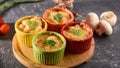 Closeup casserole with cheese in colorful cocoanuts with mushrooms and vegetables on gray background