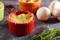 Closeup casserole with mushrooms under cheese crust in multicolored cocoanuts on gray background