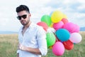 Closeup of casual man with balloons and sunglasses
