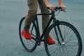 Closeup of casual man legs riding classic bike on city road