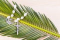 Closeup Catholic rosary with crucifix and beads on palm leaf