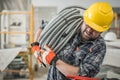 Contractor Carrying Electrical Conduit