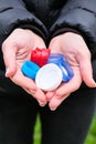 Closeup at caucasian female hands full of colorful plastic bottle cups, handful of waste of plastic lids. Recycling Royalty Free Stock Photo