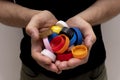 Closeup at caucasian hands full of colorful plastic bottle cups, Royalty Free Stock Photo