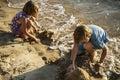 Closeup of caucasian kids playing with the sand together at the Royalty Free Stock Photo