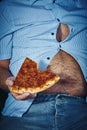 Man with a beer belly eating pizza Royalty Free Stock Photo