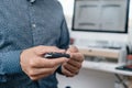 man in the office pricking his finger with a fingerstick