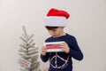 Closeup of a Caucasian pouting boy holding a tablet with 'Naughty list' written on it