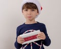 Closeup of a Caucasian pouting boy holding a tablet with 'Naughty list' written on it