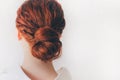 Closeup Of A Caucasian Red-haired Young Woman. The female model has curly curls twisted into a bundle. She is isolated