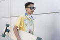 Closeup of caucasian teenage boy with skateboard. He is  on a wall Royalty Free Stock Photo