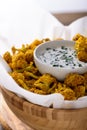 Cauliflower in batter in wooden bowl with sour cream sauce and herbs Royalty Free Stock Photo