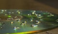 Closeup of a CD with water drops on it on the table under the lights with a blurry background Royalty Free Stock Photo