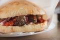 Closeup of Cevapi dish served on a plate. Traditional balkan cuisine, minced meat rolled into small sausages served in a bun with Royalty Free Stock Photo